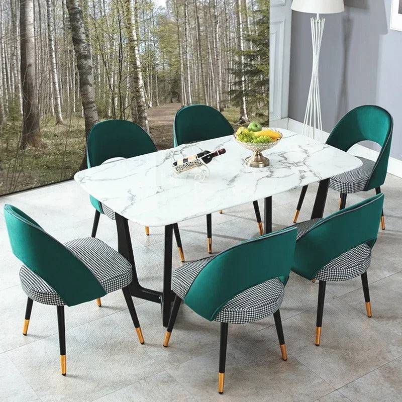 a dining table with a marble top and green chairs