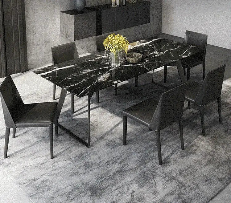 a dining room table with chairs and a vase of flowers