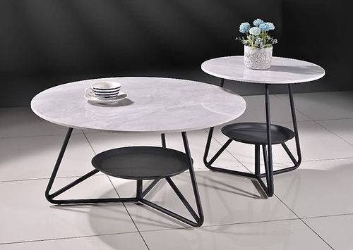 a white table and two black chairs on a white tile floor