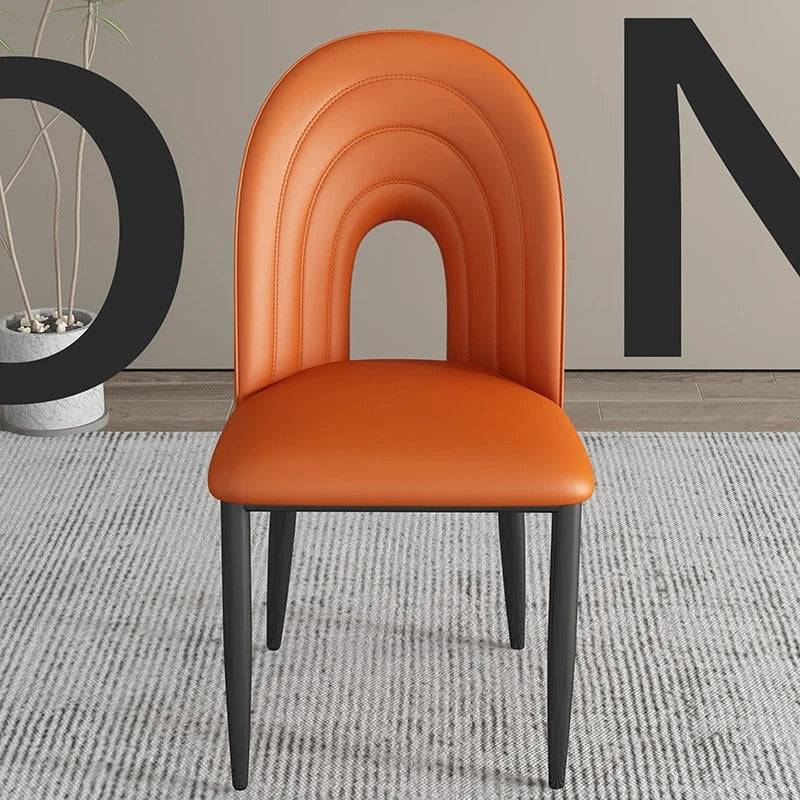 an orange chair sitting in front of a wall