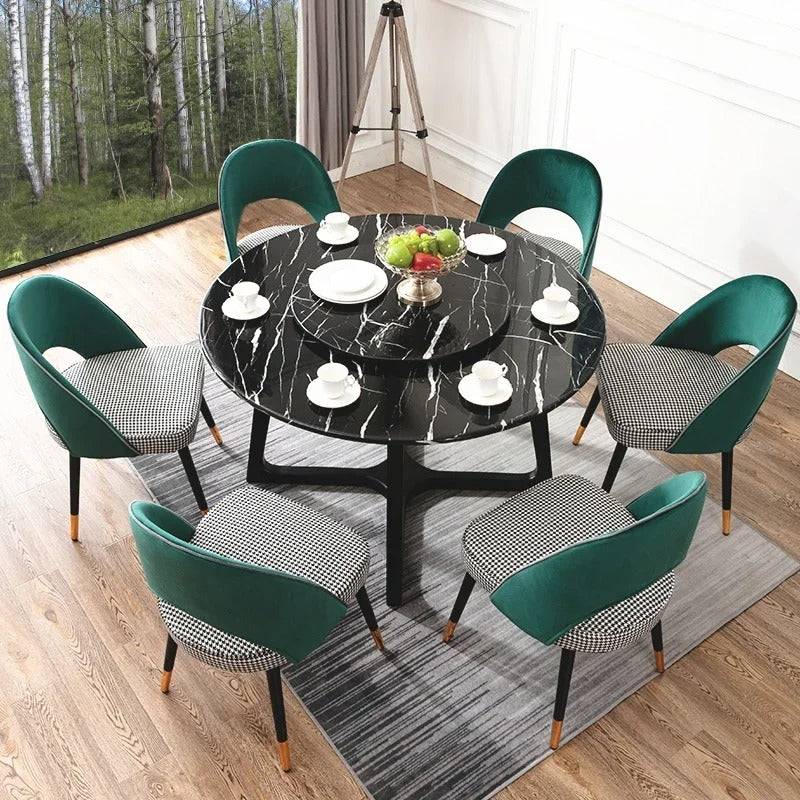 a dining room table with green chairs and a black marble top