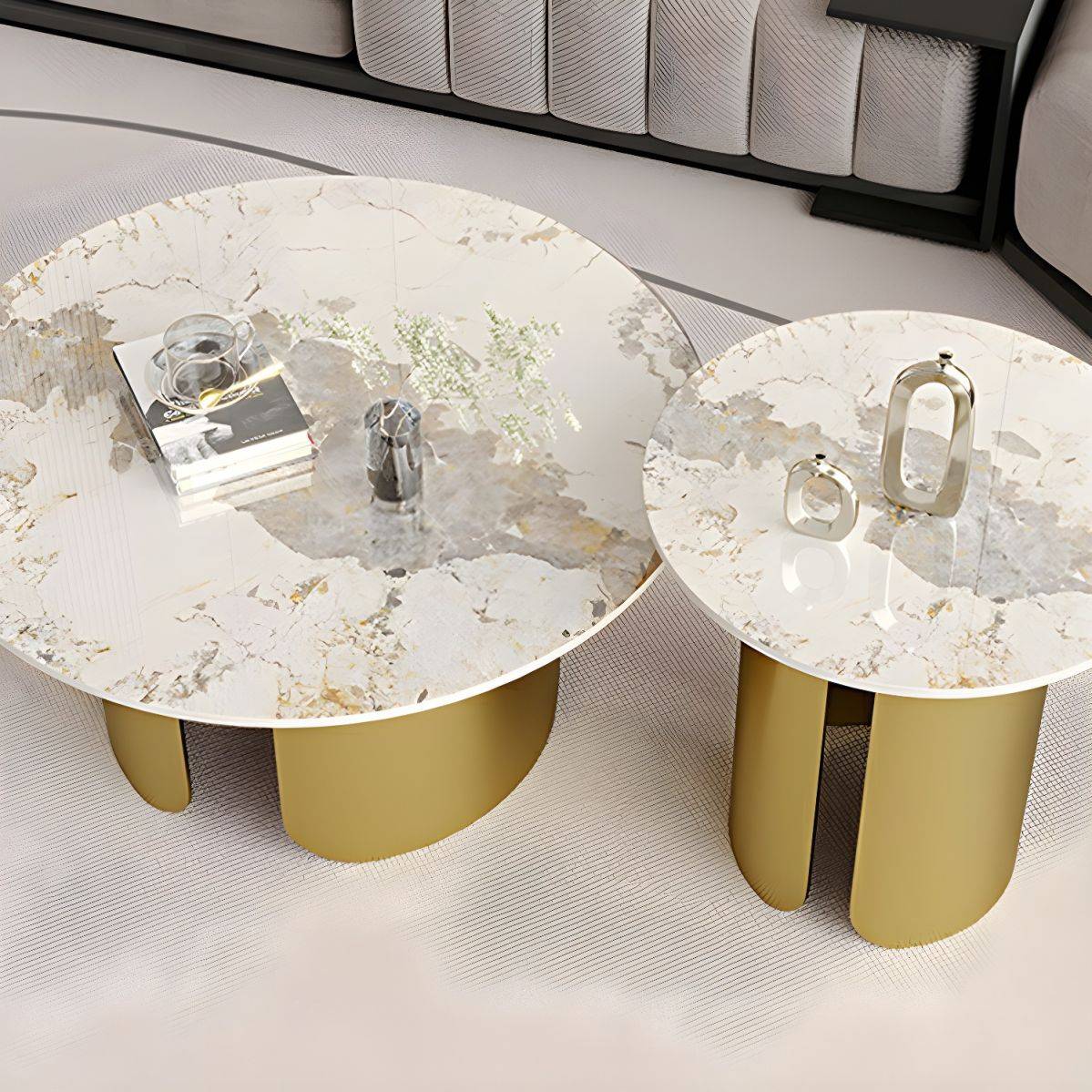 two white and gold tables sitting on top of a bed