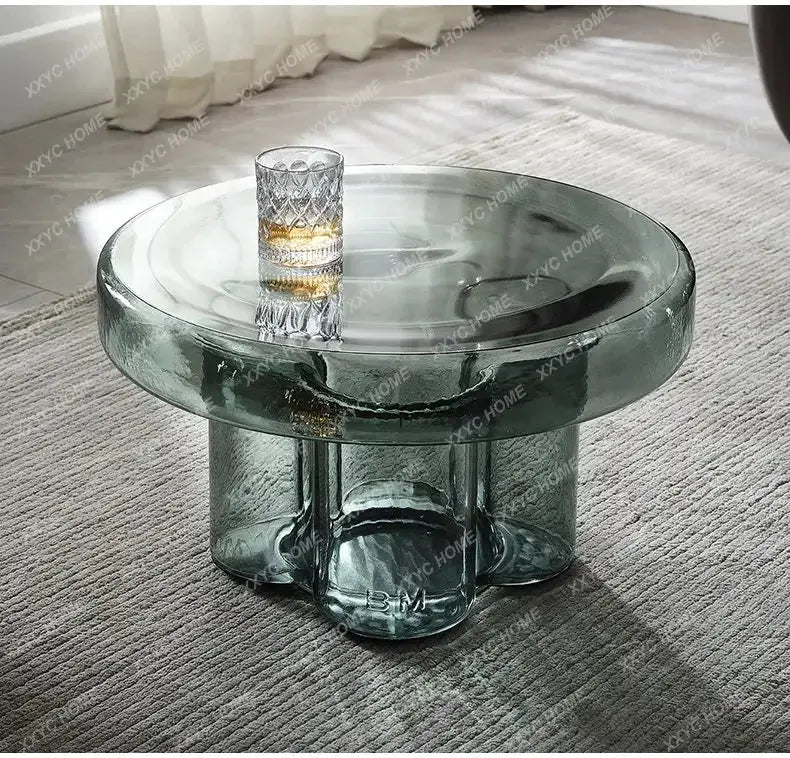 a glass coffee table with a whiskey glass on top