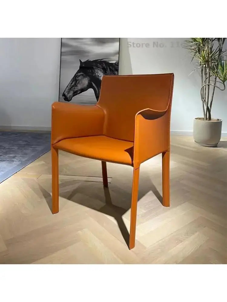 an orange chair sitting in a room next to a potted plant