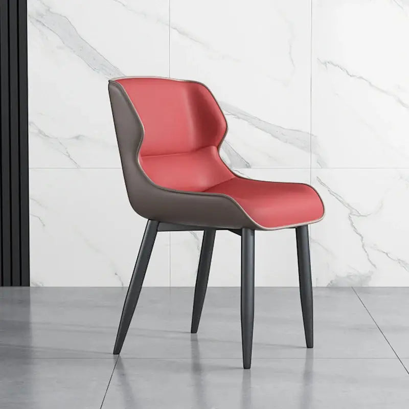 a red and grey chair sitting in front of a marble wall