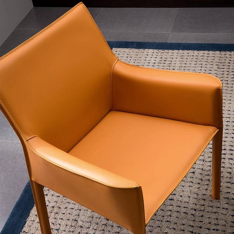 a tan leather chair sitting on top of a rug