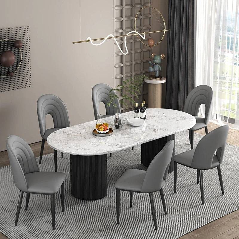 a dining room with a marble table and grey chairs